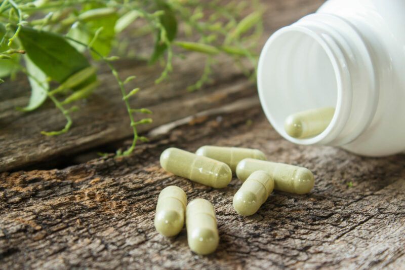 Herb capsule on old wood